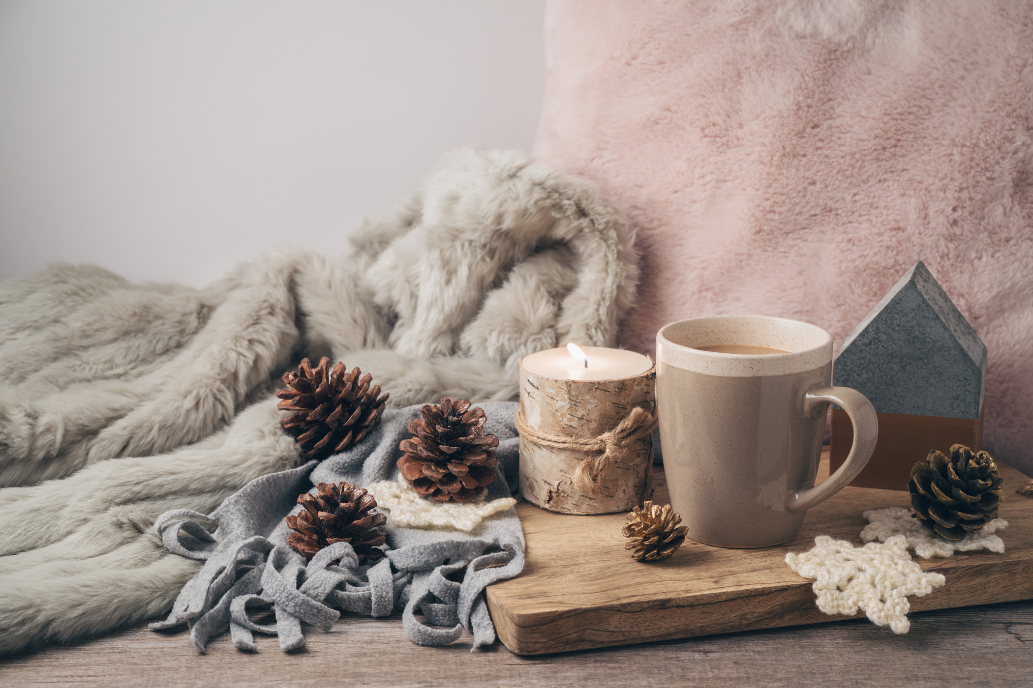 Hygge Scandinavian style concept with coffee cup, candles and pine corn